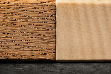 Macro comparison of porous open-grain red oak beside tight closed-grain hard maple, showing the pore structure that matters for cutting boards