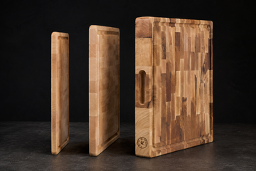Maple cutting boards of increasing thickness stood on edge, comparing thin, standard, and 1.75-inch profiles