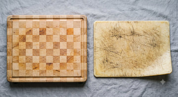 Aged end-grain maple cutting board beside a worn scored plastic board
