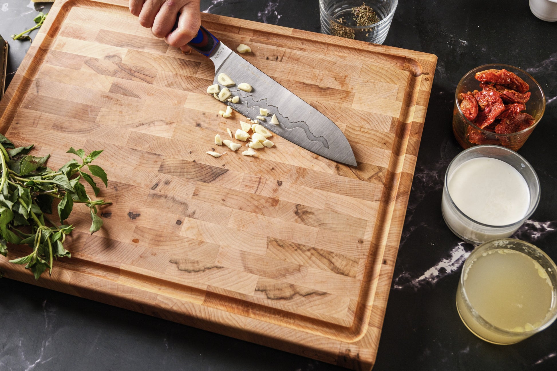 Mincing garlic on the Bevel and Bond end-grain maple cutting board