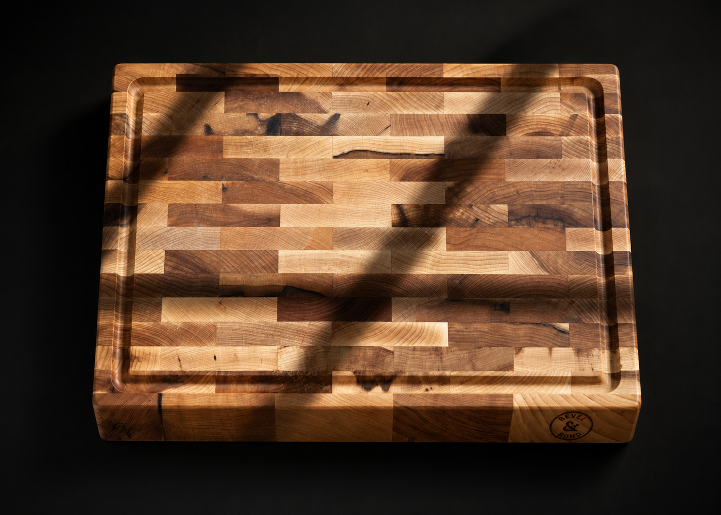 Macro view of the end-grain surface of a Bevel and Bond hard maple cutting board, showing the tight mosaic of upright wood fibers that lets a knife edge settle between them instead of cutting across them.